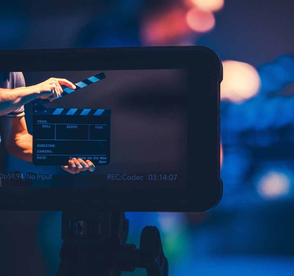 Film Production Reference Monitor. Modern Video Making Equipment. Men with Clapperboard on the Screen.